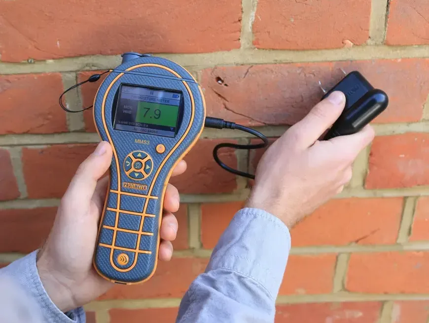 Moisture meter checking a brick wall after water exposure
