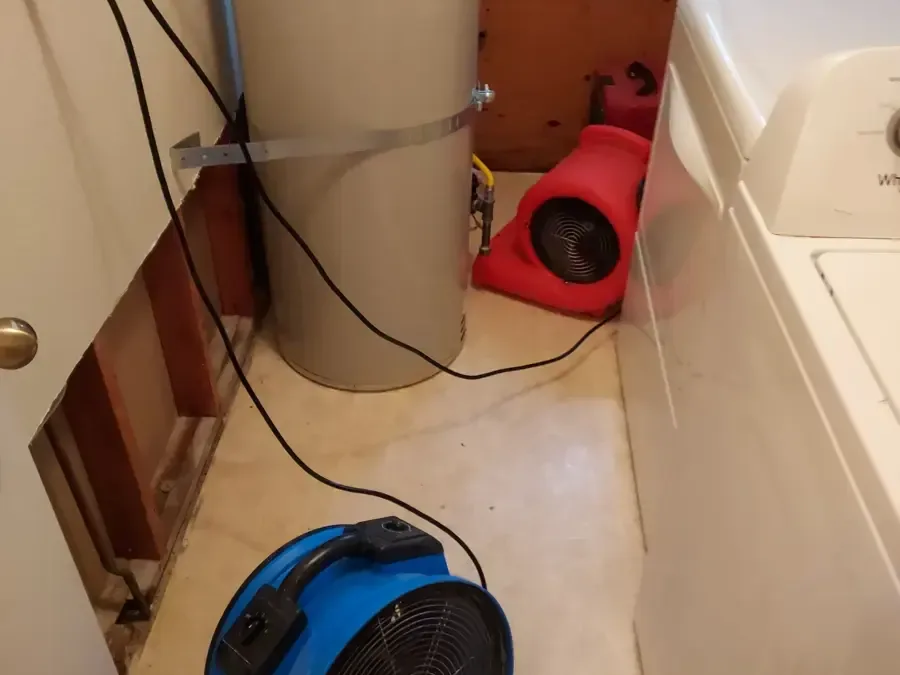 Red and blue air movers sit beside a washer and water heater