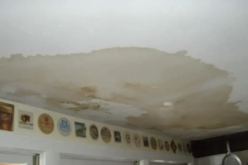 Large water stain spreading across a kitchen ceiling