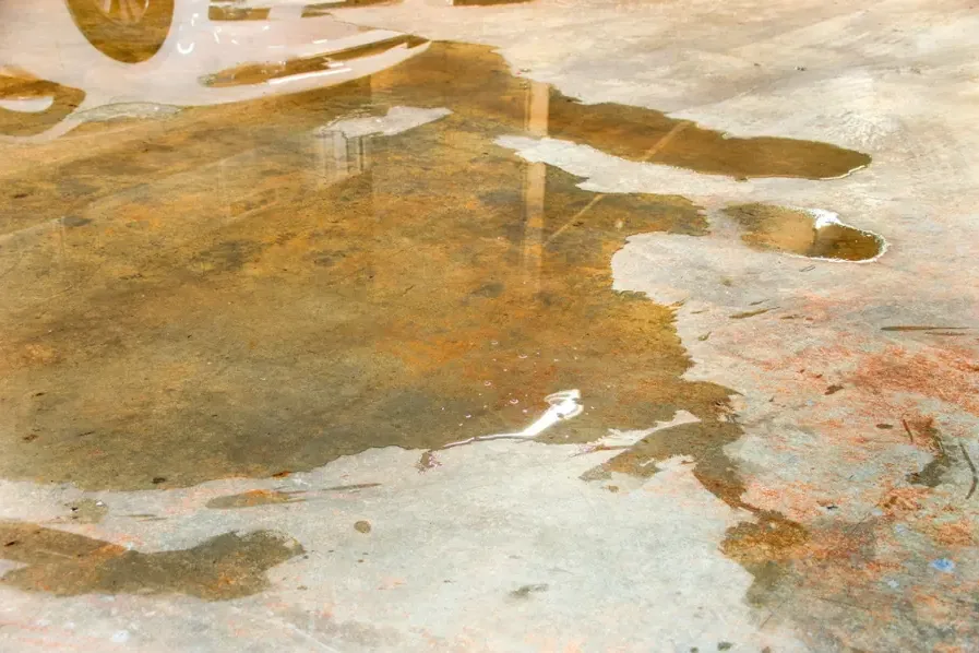 Standing water spread across an exposed concrete floor